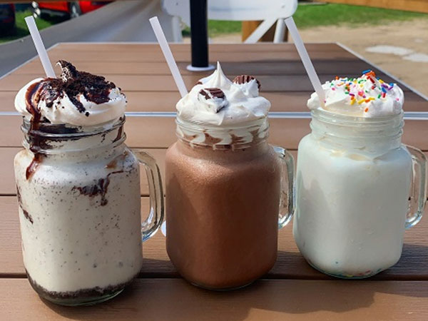 three milk shakes in glass mugs