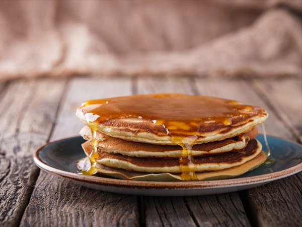 pancakes and maple syrup on a plate.