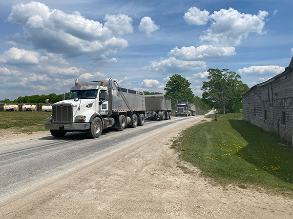Dump trucks ready to turn onto Wilcox Lake Road