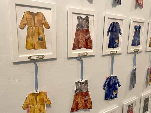 Miniature paintings of each dress by Karch-Ackerman hang on one wall