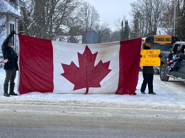 Protesters holding flag in Flesherton greeting Freedom Convoy 2022