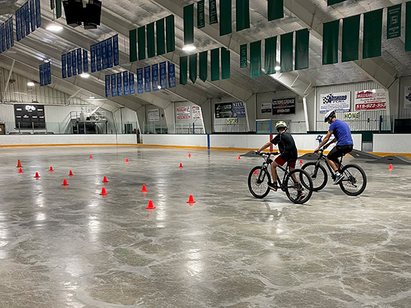 Belanger leads participants over a course familiarizing them with signalling, shoulder checks, maneuvering bikes around obstacles and over tracks with a focus on safety.