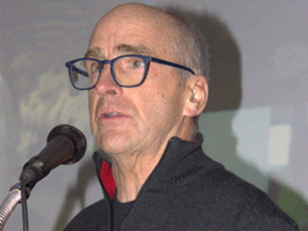 Mike Robbins speaking at the microphone.