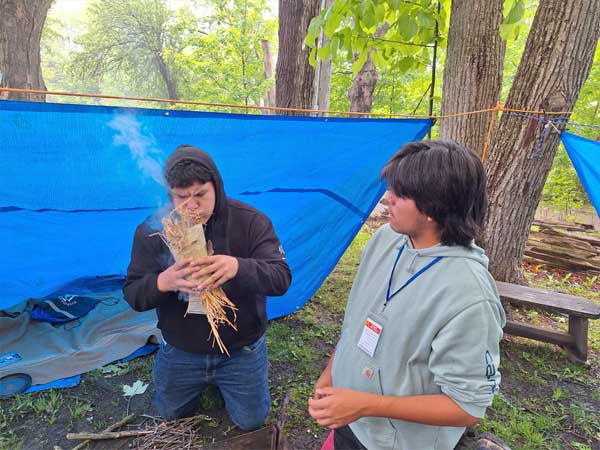 Two boys starting fire outdoor activity