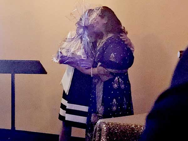 Karen Cox presents a gift to Monica Singh Soares