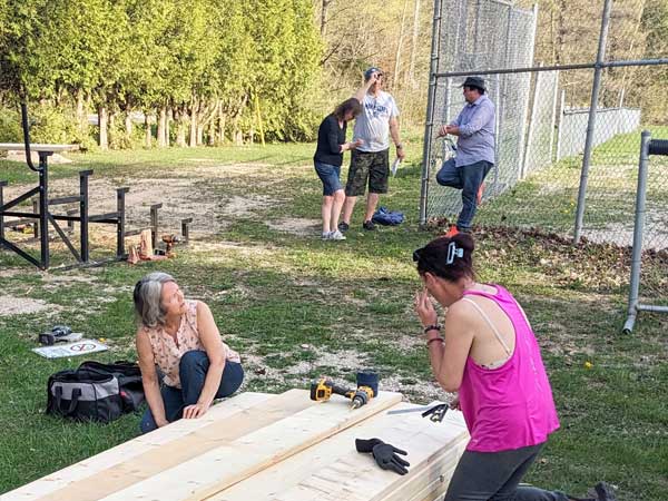 Volunteers measuring wood for bleacher seats